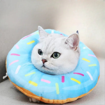 Cat lying on a blue donut-shaped pet bed with colorful sprinkles.