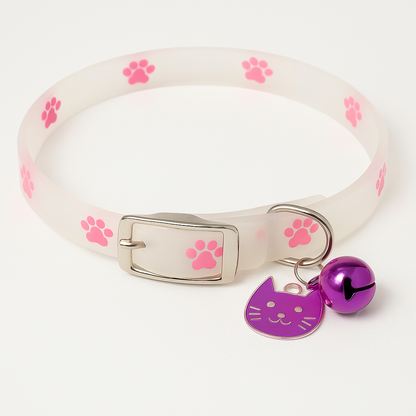White pet collar with pink paw prints, a purple bell, and a cat-shaped tag on a white background.