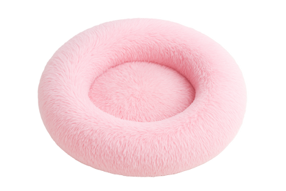 Pink fluffy donut-shaped pet bed on a white background